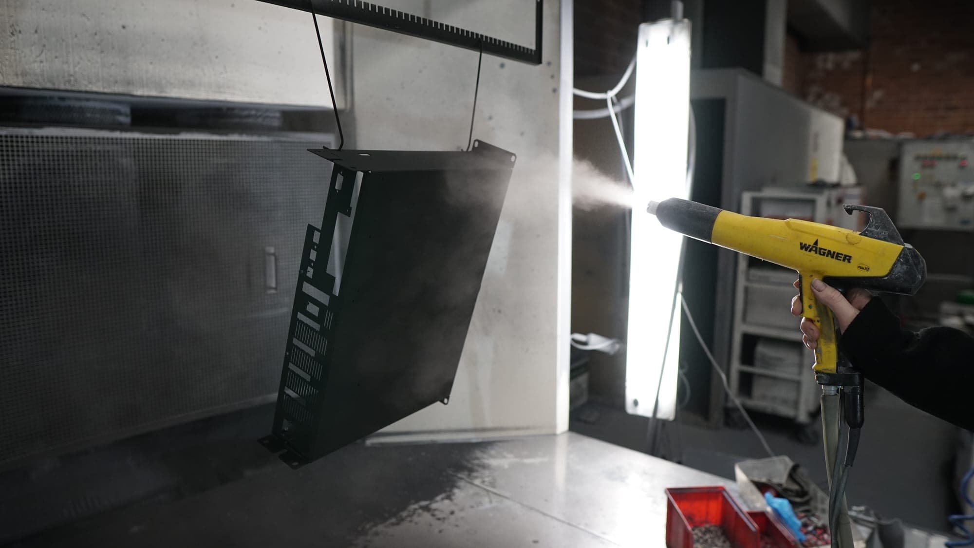 Wagner powder coating gun spraying a suspended enclosure